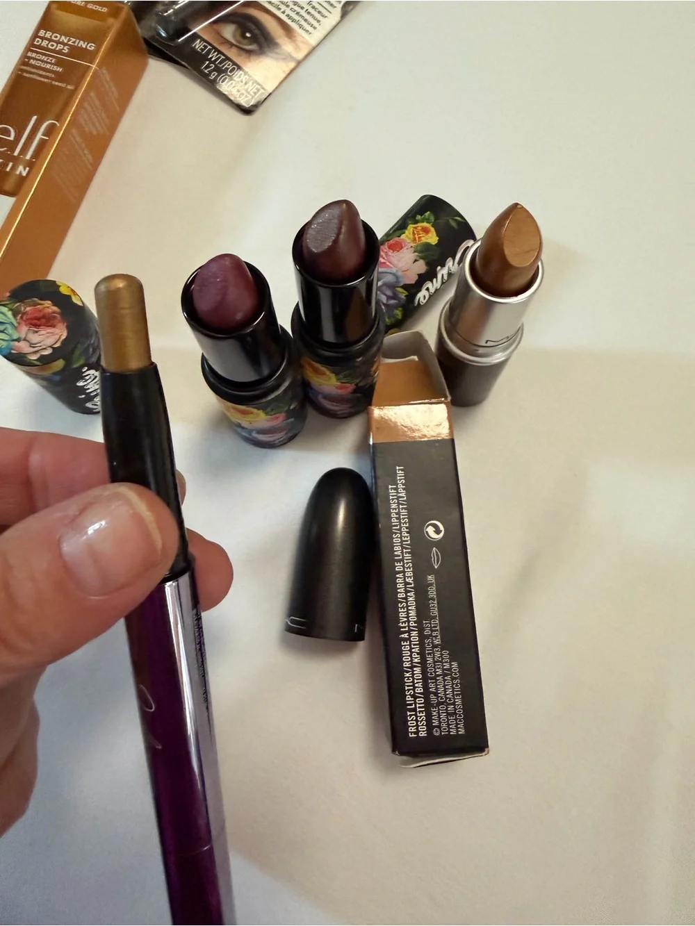 Assortment of women’s lipsticks, eyeliner, eyeshadow, bronzing drops